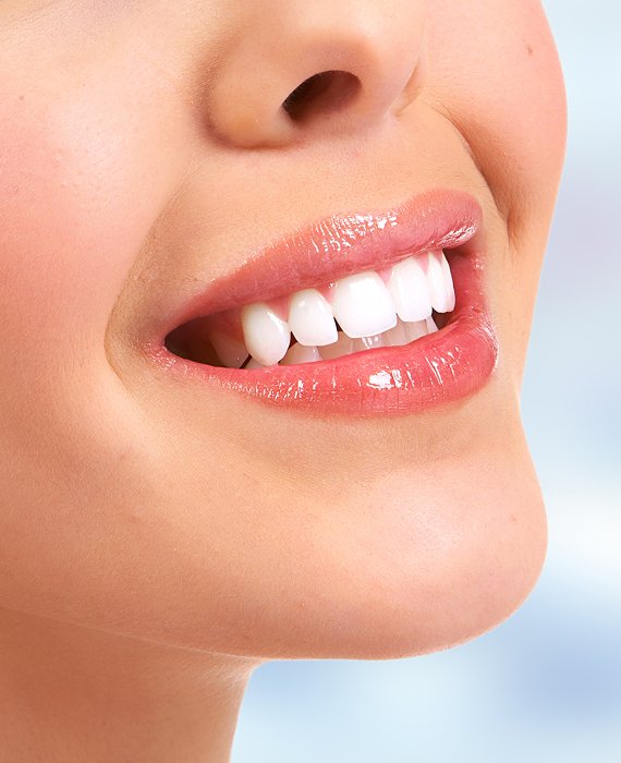 Smiling woman looking into mirror brushing her teeth smoothly